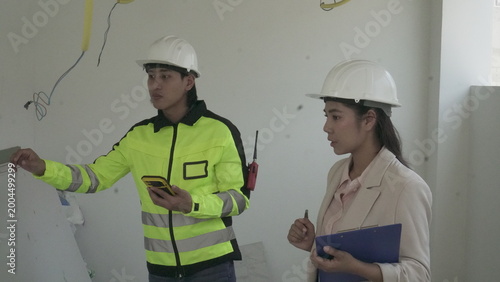 Electrician installing electrical wiring in building construction site with safety equipment