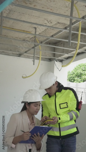 Electrician installing electrical wiring in building construction site with safety equipment