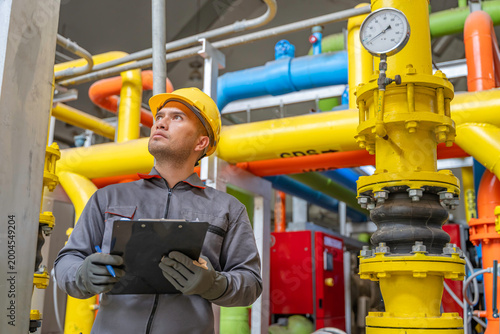 Tableau sur toile Asian engineer wearing glasses working in the boiler room,maintenance checking t
