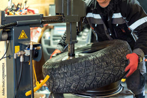 Foto Person works on changing a tire using a machine in a workshop during the day