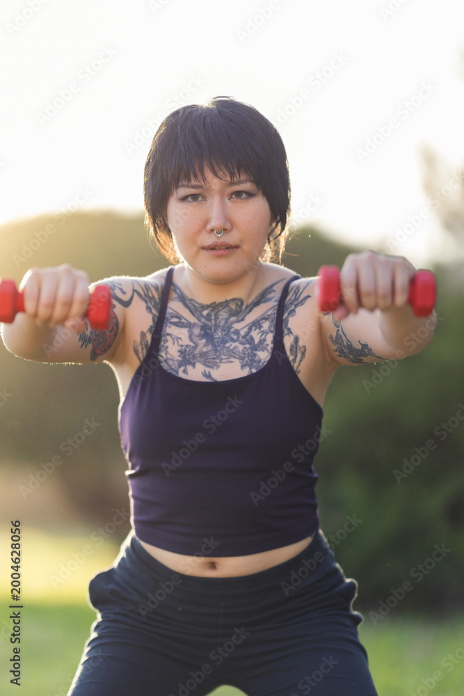 Fototapeta premium Person exercising outdoors lifting weights for fitness