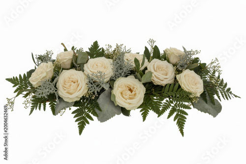 A long floral arrangement of white roses, eucalyptus leaves, and ferns on a plain white background