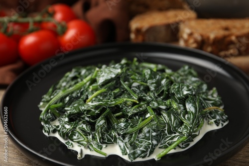 Fotografía Delicious creamed spinach served on wooden table, closeup