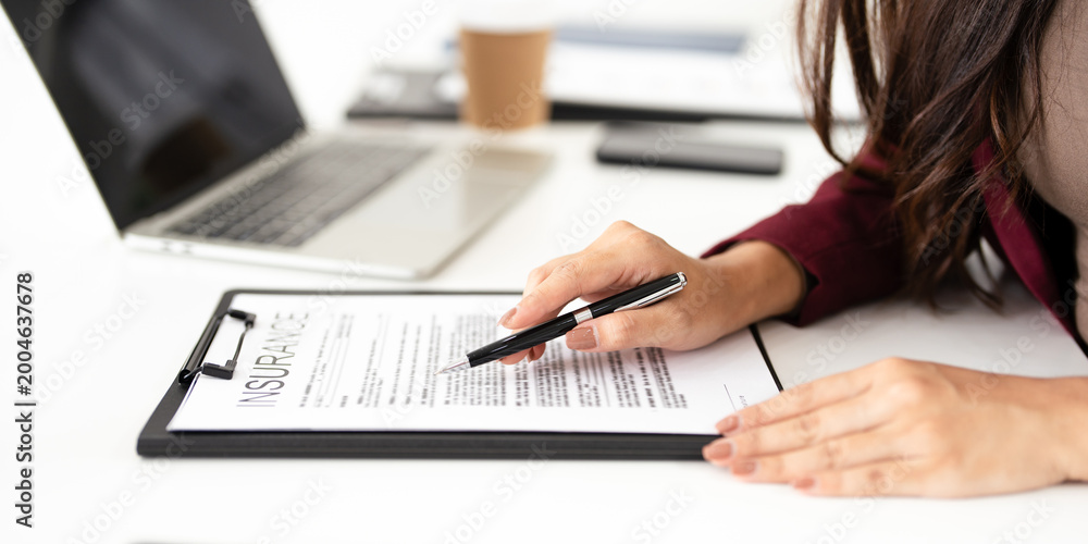 Fototapeta premium real estate agent professional reviewing documents while working on a laptop.