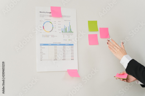 Financial Strategy with Sticky Notes: An overview of a financial document, adorned with notes, highlighting a strategic approach to monthly budgeting. This scene conveys meticulous planning.