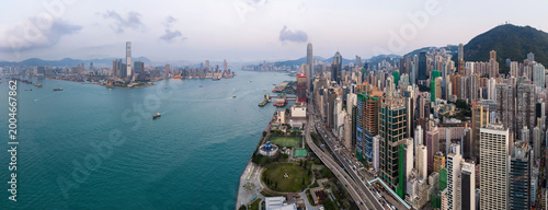 High-angle view of the bustling skyline and coastal highway in Hong Kong during the day, showcasing the city architectural scale and urban density.