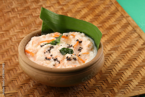 Foto Carrot Curd rice served in a banana leaf and earthen pot