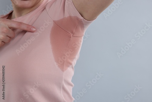 Foto Woman with sweaty armpits on light grey background, closeup