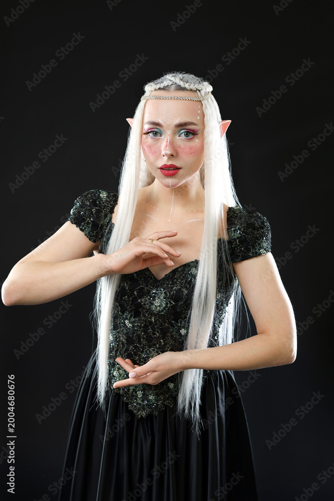 Fototapeta premium Beautiful girl dressed as elf on black background
