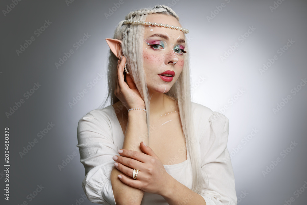 Fototapeta premium Beautiful elf girl on grey gradient background