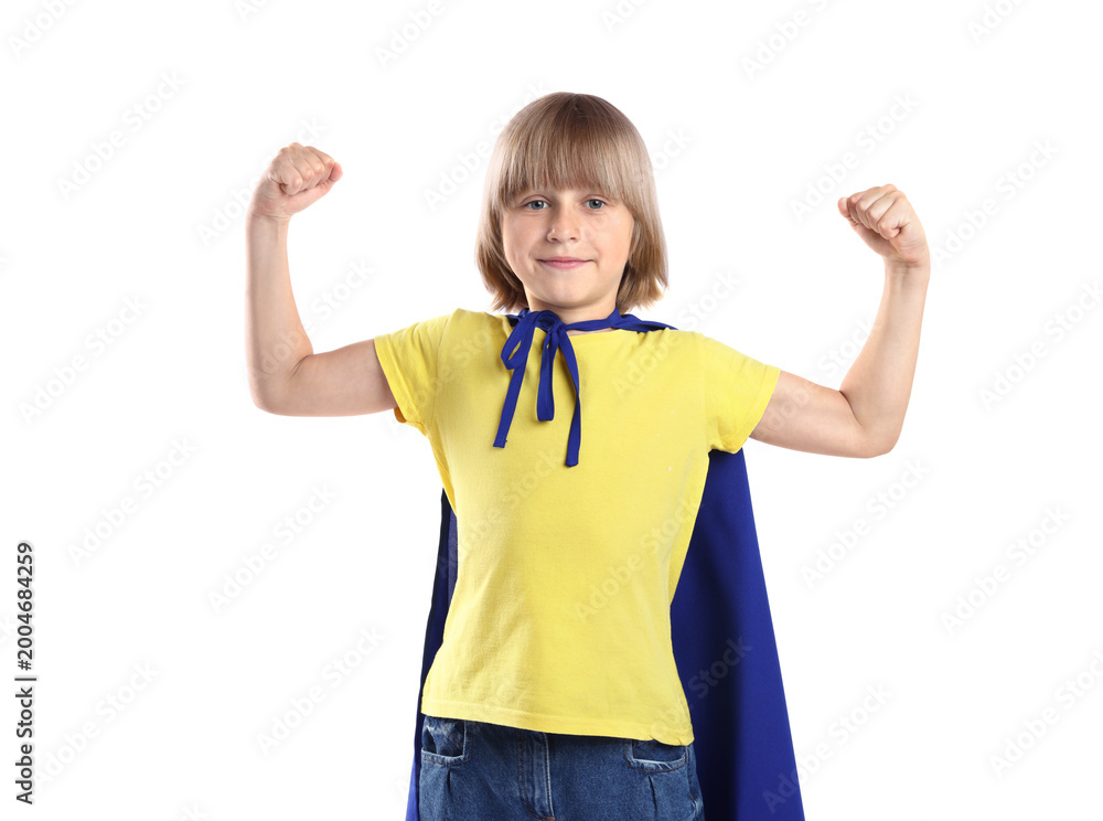 Fototapeta premium Little boy in superhero costume showing his muscles on white background