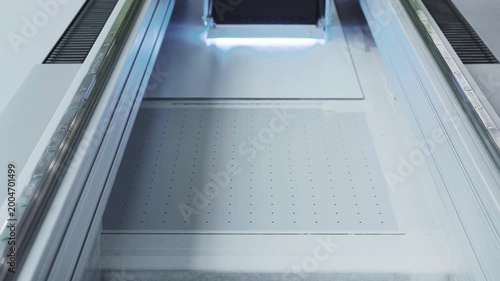 A modern glass printer prints with a large print head.