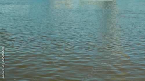 Minimalist view of calm river water. Gentle ripples create subtle texture on greenish-blue surface. Serene and tranquil background with soft, natural light. Perfect for concepts of nature or peace