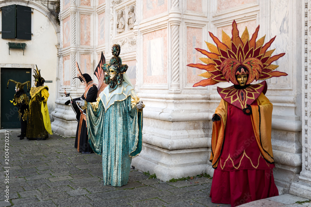 Naklejka premium Venice, Italy - February 17, 2026 - People dressed in masks for the Venice Carnival have their photos taken by tourists