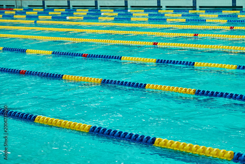 Bild auf Leinwand Empty swimming pool with clear blue water and colorful lane dividers