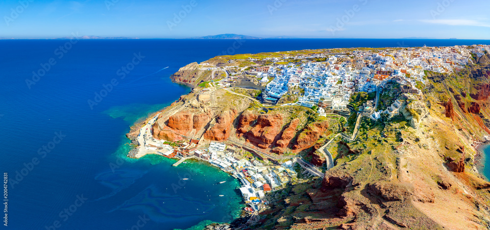 Fototapeta premium Oia town on Santorini island, Greece. Traditional and famous houses and churches with blue domes over the Caldera, Aegean sea