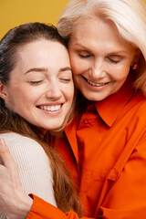 Mother and adult daughter sharing loving hug celebrating