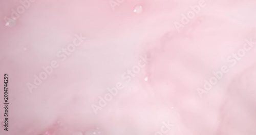 Super Slow Motion Soft Pink Ink Twirls Gracefully In Water Amidst Floating