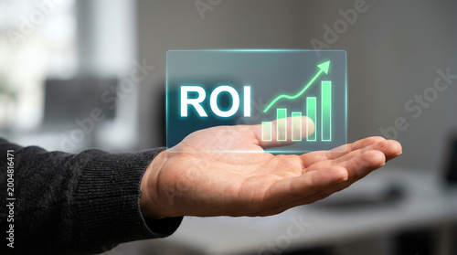 Hand displaying holographic return on investment concept with glowing ROI text and an ascending growth chart, symbolizing financial success and future business strategy