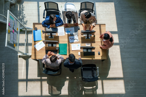 Business model marketing strategy ai teamwork meeting office data planning drive diverse team around table as leaders review chart laptop note and document from top view shaping growth plan with