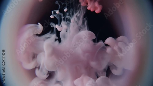 Pink ink dropping in water.