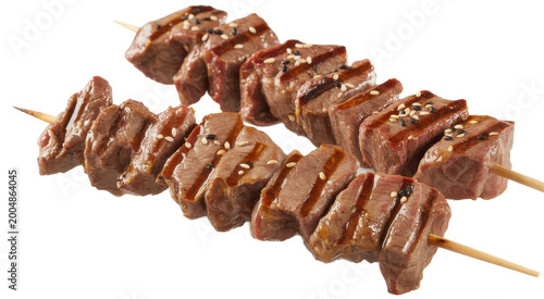 Two grilled beef skewers seasoned with sesame seeds and glaze on wooden sticks isolated