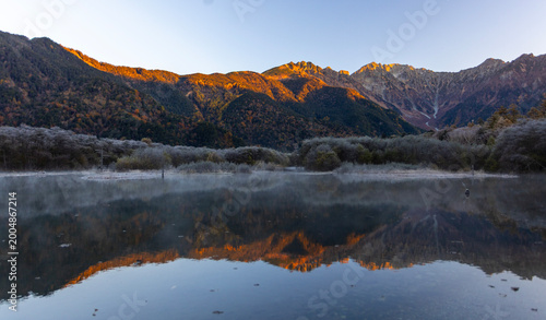 mount hotaka or Mount Hotakadake with the reflection of Taisho ike pond in Japan's Hida Mountains