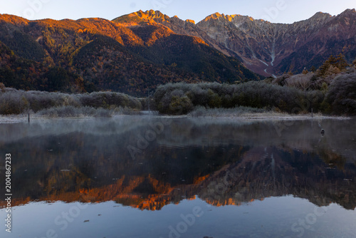 mount hotaka or Mount Hotakadake with the reflection of Taisho ike pond in Japan's Hida Mountains