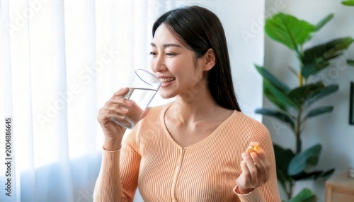 Healthy Asian woman enjoying a snack with water indoors.