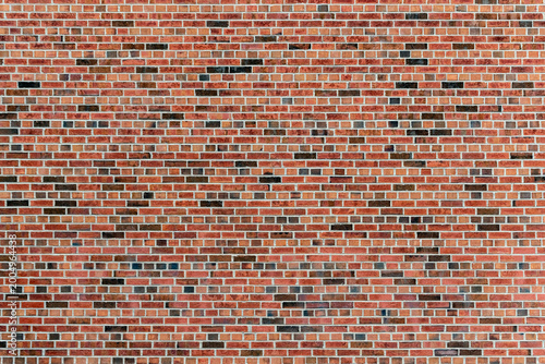 Fragment of a red brick wall with black brick inserts, for use as an abstract background and textures.