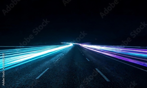 Abstract blur of light trails from moving vehicles on a dark highway at night, representing speed and motion