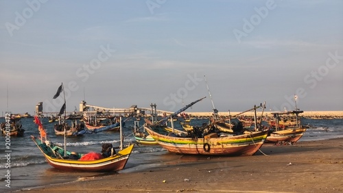 sunset atmosphere on a beach full of fishing boats
