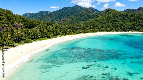 Stunning Aerial View of Tropical Beach with Turquoise Water and Lush Mountains.