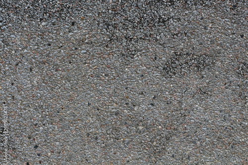 Close-up texture of a grey aggregate concrete surface with small pebbles