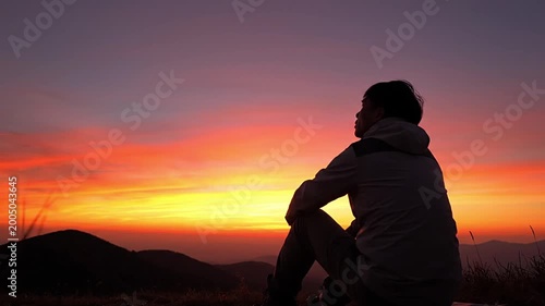 Man finding peace and clarity through mindfulness and introspection during a breathtaking sunset in a serene natural landscape. Ideal for concepts of freedom, meditation, and mental wellness.