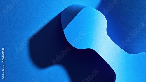 Abstract, blue paper sculpture with dynamic shadows, creating curved, flowing forms