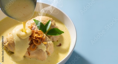 Steaming Savory Chicken Curry with Crispy Fried Onions and Fresh Green Leaves in a Bowl