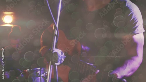 Photographer raising DSLR and aiming, capturing music band while animated bokeh over singer, drums