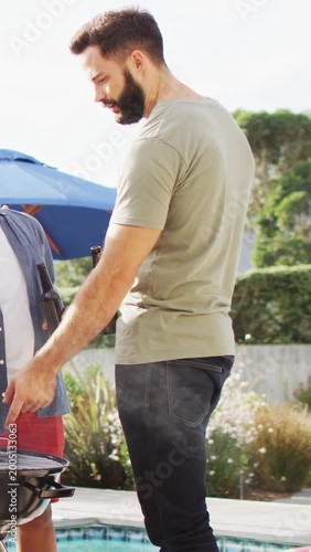 Vertical video: Bearded man leaning over grill checking food with smoke rising, app icons appearing