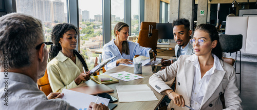 Workgroup collaboratively evaluates plans around conference table