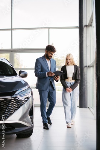 Salesman consulting woman customer buying new car