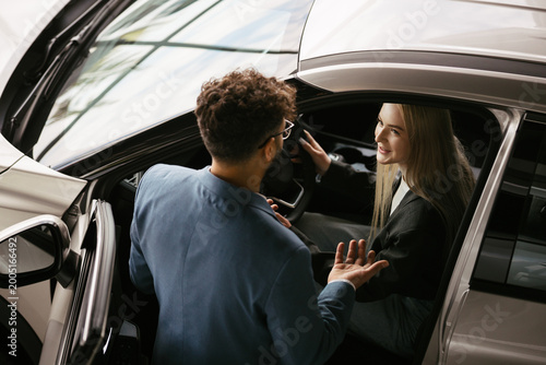 Obraz na płótnie Car salesman assisting woman trying new automobile