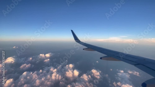 Airplane Wing Over Cloudscape with Blue Sky Aerial View