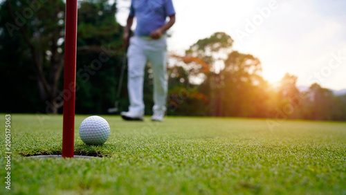 Obraz na płótnie Golfers are putting golf in the evening golf course golf backglound