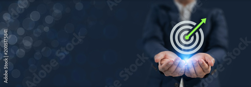 Goal Achievement and Business Growth. Holding a glowing target with upward arrow, representing clear goals, strategic focus and measurable growth driven by performance and precision.