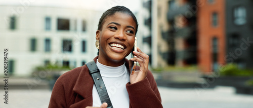 Foto Smile, business or black woman with phone call in city, settlement offer negotiation or case update