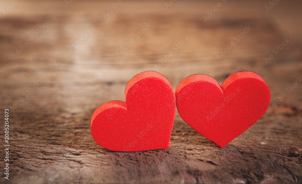 Fototapeta premium Two red hearts on wooden background, valentine's day concept