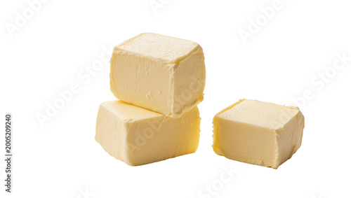 Yellow creamy butter cubes stacked and single on plain surface