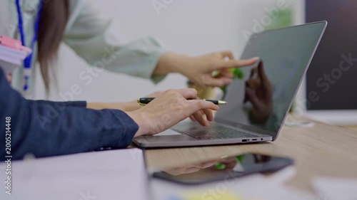 The focused hands typing on a laptop in a modern workspace. 
