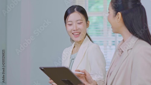 Close-up of successful businesswoman using digital tablet in front of modern business building.